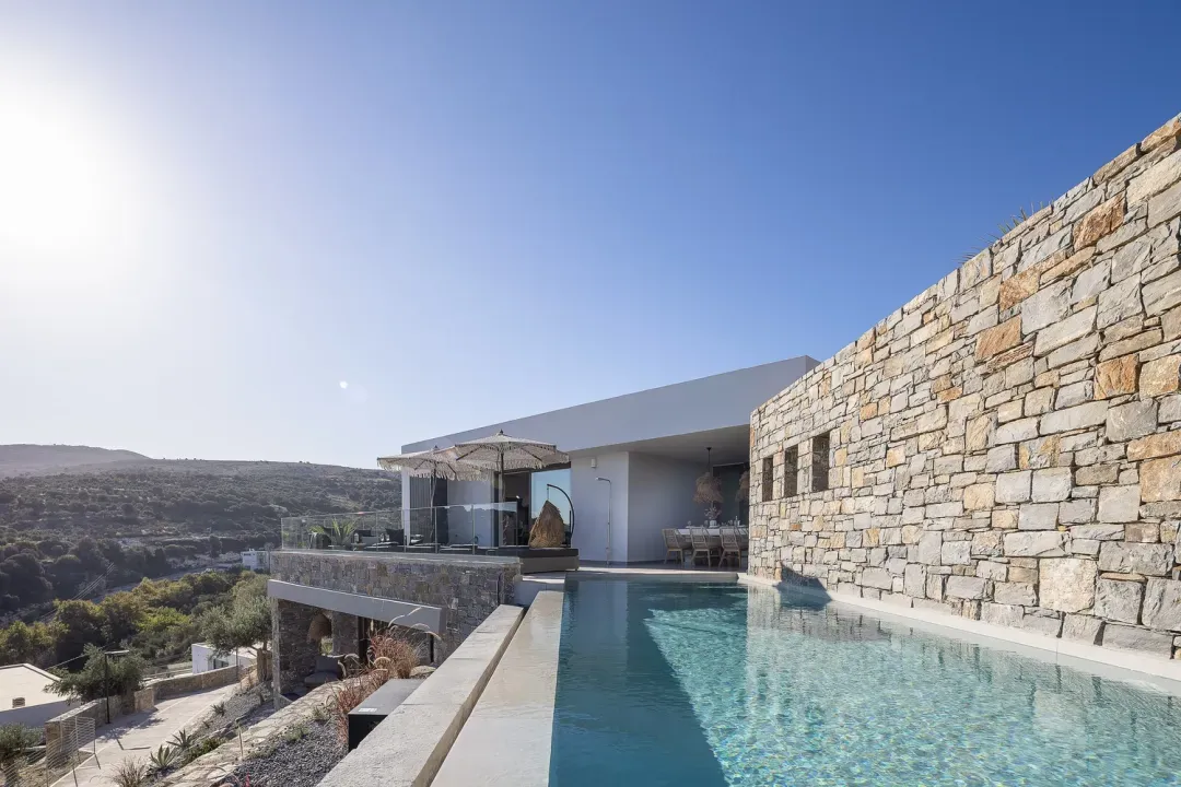 Villa ANDRIOTIS mit Infinity-Pool und Natursteinmauer bei Tag