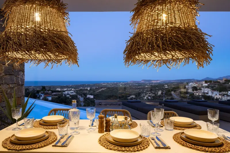Gedeckter Essplatz auf der überdachten Terrasse mit Blick auf Pool und Meer